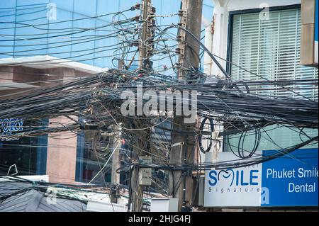 PHUKET, THAILAND - 13. MÄRZ 2018. Lampenpfosten auf Gewirr von elektrischen Drähten Hintergrund. Redaktionelle Tagesaufnahme Stockfoto