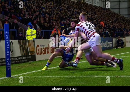 Josh Thewlis (22) von Warrington Wolves wird von Sam Halsall (25) und Abbas Miski (24) von Wigan Warriors angegangen Stockfoto