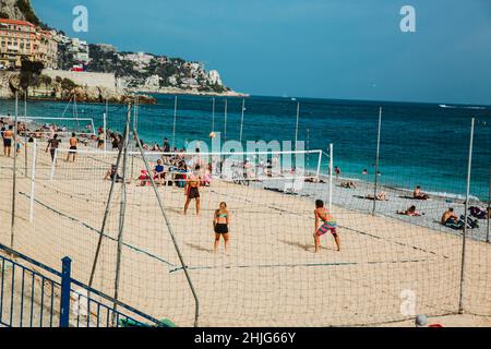 NIZZA, FRANKREICH - 26. JUNI 2017: Menschen, die am Steinstrand sonniges Wetter genießen und Beachvolleyball spielen in Nizza, in der Nähe der Promenade des Anglais, F Stockfoto