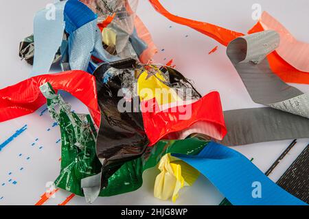 Farbige Kanalbänder. Bunte Rollen von regenbogenfarbenem Klebeband auf weißem Hintergrund. Farbliches Klebeband, Tape-Isolate, Leime, Zubehör für Stockfoto