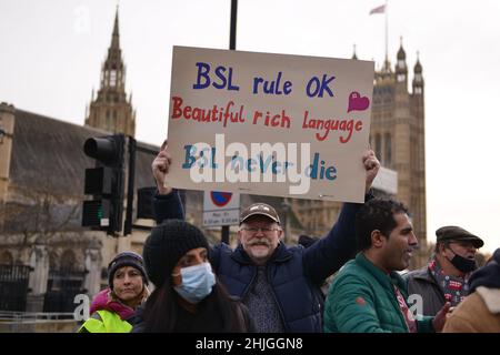 Eine Protesterin sah, wie sie während der Demonstration ein Plakat mit ihrer Meinung hielt. Britische Gebärdensprache und gehörlose Gemeinschaft versammelten sich gegenüber dem britischen Parlament zur Unterstützung des BSL-Gesetzes (British Sign Language), das die Gebärdensprache als Amtssprache des Vereinigten Königreichs anerkennt. Stockfoto