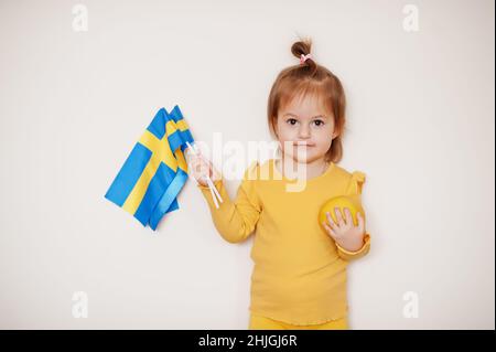 Baby Mädchen in gelb mit Zitrone und Schweden Flagge, isolierter Hintergrund. Stockfoto