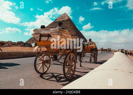 Kairo Ägypten Dezember 2021 Rückansicht eines Pferdewagens, der um die großen Pyramiden von gizeh reitet. Für Touristen ist die Gegend sehr beliebt Stockfoto