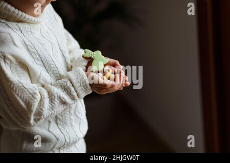 Kleiner Junge mit schokoladenöstereiern und Häschen in den Händen. Stockfoto