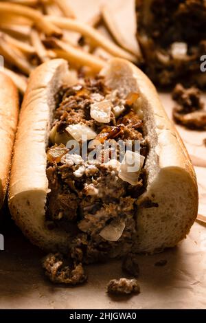 Käsesteaks und Pommes auf Pergamentpapier. Stockfoto