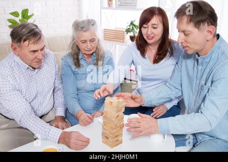 Familie sammelt hölzerne Pyramide zusammen am Tisch zu Hause Stockfoto