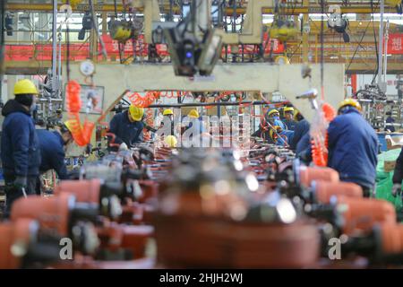QINGDAO, CHINA - 20. JANUAR 2022 - Arbeiter passen eine Antriebsachse-Baugruppe an einer Antriebsachse-Montagelinie in Qingdao, der ostchinesischen Provinz Shandong, an Stockfoto