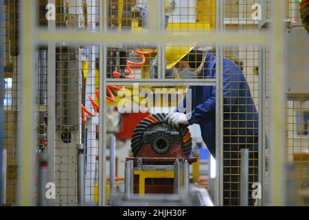 QINGDAO, CHINA - 20. JANUAR 2022 - Ein Qualitätsprüfer prüft Teile eines Auftrags, der automatisch an der automatischen Montagelinie der Achse montiert wird Stockfoto