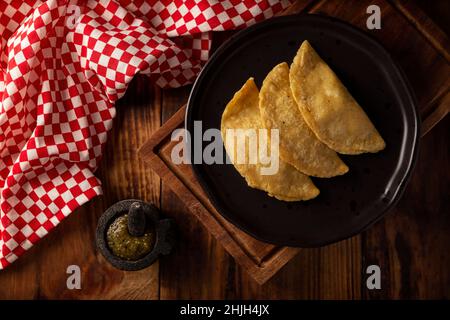 Quesadillas Fritas. Traditionelle mexikanische Vorspeise „garnacha“. Tiefgebratene handgemachte Maistortilla, die mit einer Vielzahl von Zutaten gefüllt werden kann, Stockfoto