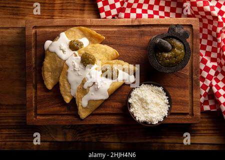 Quesadillas Fritas. Traditionelle mexikanische Vorspeise „garnacha“. Tiefgebratene handgemachte Maistortilla, die mit einer Vielzahl von Zutaten gefüllt werden kann, Stockfoto