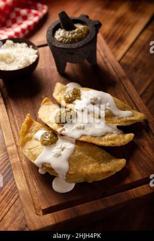 Quesadillas Fritas. Traditionelle mexikanische Vorspeise „garnacha“. Tiefgebratene handgemachte Maistortilla, die mit einer Vielzahl von Zutaten gefüllt werden kann, Stockfoto