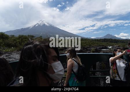 Petrohue, Los Lagos, Chile. 29th Januar 2022. Menschen mit Gesichtsmasken besuchen den Fluss Petrohue im Süden Chiles, mit dem Vulkan Osorno im Hintergrund, mitten in den Sommerferien. (Bild: © Matias Basualdo/ZUMA Press Wire) Stockfoto