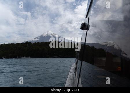 Petrohue, Los Lagos, Chile. 29th Januar 2022. Der Vulkan Osorno spiegelt sich in einem Bootsfenster auf dem Lake Todos Los Santos in Petrohue, Südchile. (Bild: © Matias Basualdo/ZUMA Press Wire) Stockfoto