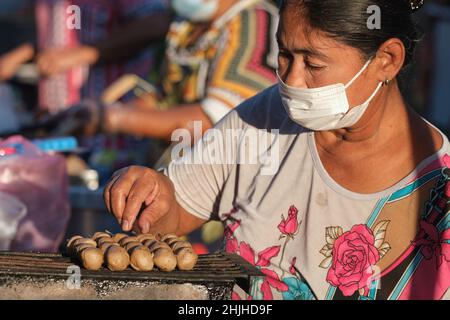 Ein Straßenhändler, der auf einem Markt in Ban Yuan, Bangkok, Thailand, Würstchen gegrillt hat, eine alte Siedlung vietnamesischer und kambodschanischer Einwanderer Stockfoto