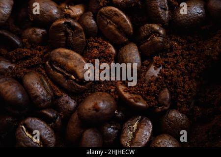 Makrofotografie. Mischung aus Kaffeebohnen und gemahlenem Kaffee. Blick von oben. Werbliche Kulisse mit frisch geröstetem Kaffee. Rohstoffe der neuen Ernte für duftende belebende Getränke. Stockfoto