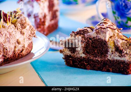 Schokoladenkuchen mit Kirschen auf blauem Hintergrund Stockfoto