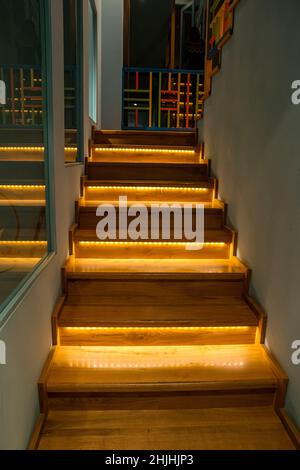 Beleuchtete Treppe mit Holztreppen und nachts im Inneren eines großen Hauses beleuchtet. Stockfoto