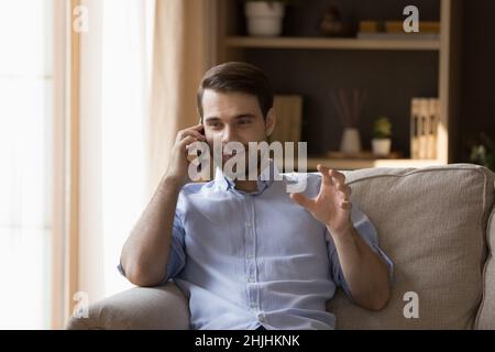 Entspannter, glücklicher junger Kaukasusmann, der das Telefongespräch hielt. Stockfoto