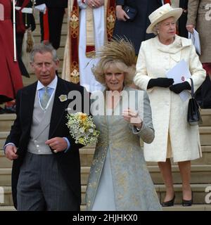 Aktenfoto vom 09/04/2005 von dem Prince of Wales, der die St. Georges Chapel in Windsor verließ, nachdem er seine ehemalige Geliebte Camilla Parker Bowles geheiratet hatte, wodurch sie zur Königlichen Hoheit und zur Herzogin von Cornwall wurde. Königin Elisabeth II. (Im Hintergrund) nahm an ihrem religiösen Segen Teil, war aber nicht bei ihrer standesamtlichen Zeremonie anwesend. Ausgabedatum: Sonntag, 30. Januar 2022. Stockfoto