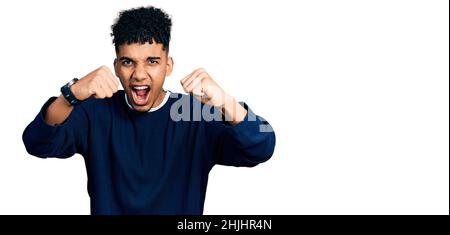 Junger afroamerikanischer Mann in lässiger Kleidung wütend und verrückt Erhöhung der Fäuste frustriert und wütend, während schreien vor Wut. Wut und aggressive Co Stockfoto