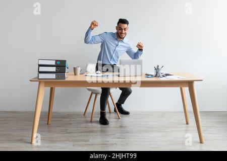 Begeisterter Mann mit Laptop feiert Erfolg Schütteln Fäuste schreiend ja Stockfoto