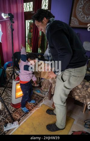 Als der Vater ihm das Telefon aus der Hand nimmt, wird der Sohn wütend und versucht, ihn zu töten. Stockfoto