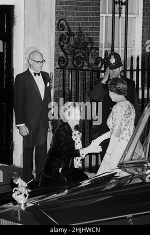 Datei-Foto vom 4/12/1985 von Premierministerin Margaret Thatcher, die Königin Elizabeth II. Kurz vor ihrem Eintreffen zu einem Abendessen in der Downing Street 10, London, anlässlich des 250th. Jahrestages des Amtes des Premierministers. Ehemann Denis Thatcher sieht zu, wie ein Polizist grüßt. Ausgabedatum: Sonntag, 30. Januar 2022. Stockfoto