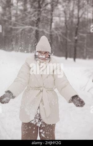 Zwei Mädchen spielen im Winter Schneebälle im Schnee in einer warmen Winterkleidung Stockfoto