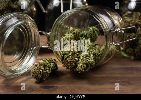 Getrocknete Hanfknospen aus Cannabis verschüttet aus einem Glas, fertig zum Verzehr. Stockfoto