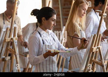 Fokussierte indisch künstlerische Klasse Schüler Mädchen Zeichnung in Farben inspiriert Stockfoto