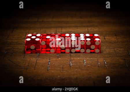 Professionelle Würfel im Casino-Stil auf einem Holztisch unter einer High-Key-Beleuchtung. Stockfoto