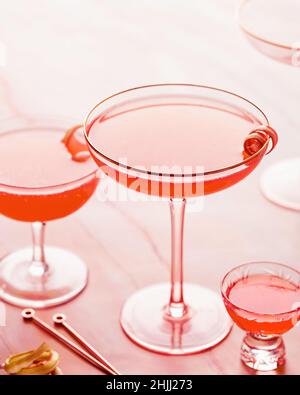 Sommer Rhabarber Erdbeer Spritz Cocktail auf rosa Marmor Hintergrund. Mädchen Party Drink Ideen. Brunch Cokctail Ideen. Vertikale Aufnahme. Selektiver Fokus Stockfoto