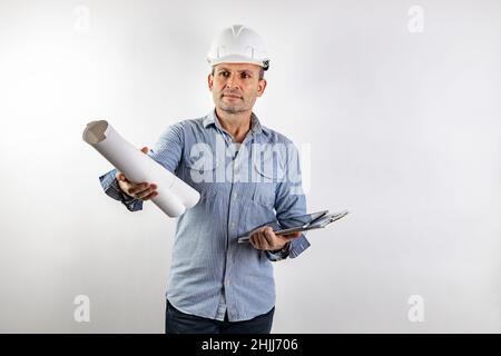 Ein männlicher Bauingenieur mittleren Alters mit Blaupausen in den Händen und einem weißen, harten Helm. Isoliertes Porträt auf weißem Hintergrund. PH-wert für männlichen Bestand Stockfoto