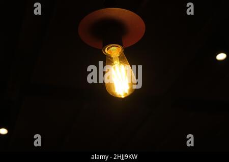 Alte Lampe, Wolfram und Vintage Retro-Lampe, schwarzer isolierter Hintergrund. Ideenentwicklung Konzeptideen. Stockfoto