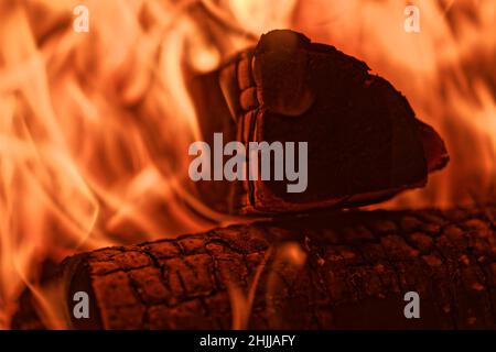 Nahaufnahme des Brennholzes, das in roten Flammen des Feuers im Kamin brennt Stockfoto