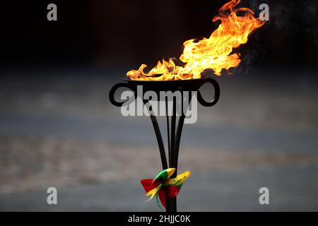 Im Freien brennen dekorative Fackeln mit Gläubigen Flieder, die in den Farben der litauischen Staatsflagge dekoriert sind Stockfoto