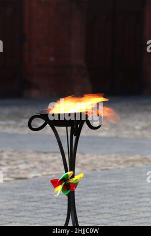 Im Freien brennen dekorative Fackeln mit Gläubigen Flieder, die in den Farben der litauischen Staatsflagge dekoriert sind Stockfoto