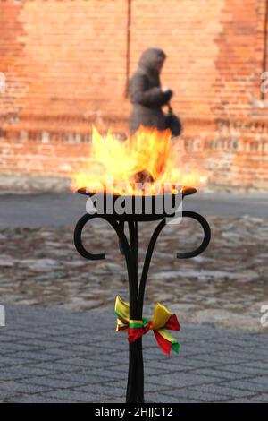 Im Freien brennen dekorative Fackeln mit Gläubigen Flieder, die in den Farben der litauischen Staatsflagge dekoriert sind Stockfoto