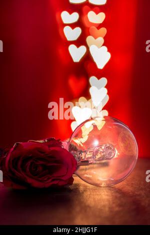 Glühbirne und Rose mit herzförmigen Bokeh Lichter Hintergrund Stockfoto
