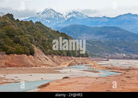 Winterlandschaft in der Bergregion Agrafa, in Zentralgriechenland, Europa. Dort kann man die Steinbrücke von Manolis sehen, die etwa 300 Jahre alt ist. Stockfoto