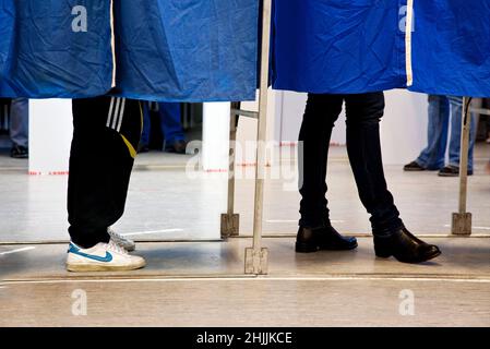 Wähler hinter dem Vorhang. Mann und Frau. Stockfoto