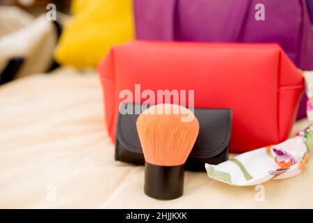 Nahaufnahme Make-up und Kosmetiktasche auf dem Bett. Stockfoto