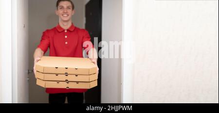 Pizzalieferung nach Hause, Lieferer mit Pizzakisten an der Tür, Lieferdienst für Lebensmittel, Kurier, Banner Stockfoto