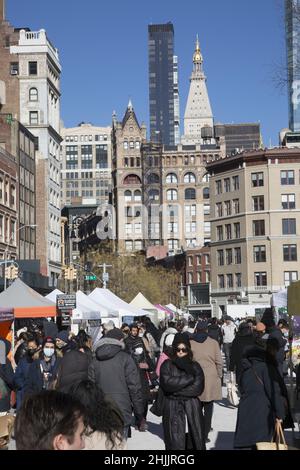 Blick nach Norden auf den Union Square Farmers Market mit Gebäuden im Hintergrund am Broadway und darüber hinaus in New York City. Stockfoto