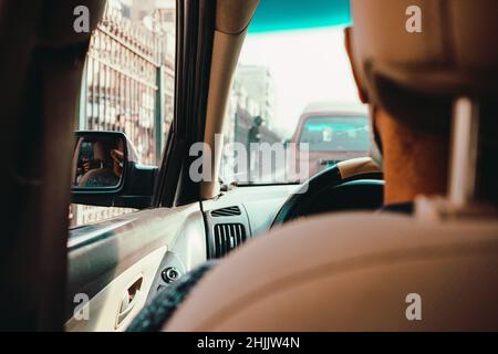 Innenansicht eines Autos, das durch die belebten Straßen von kairo, ägypten, fährt. Nicht erkennbarer Fahrer und nicht reconfizierbares Fahrzeug stecken in einem Stau Stockfoto