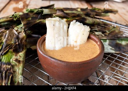 Gegrillter Fischkuchen aus gemahlenem Makrelenfisch, gemischt mit Gewürzen, dann in Bananenblätter gewickelt, über Holzkohle gegrillt, mit Erdnusssoße gegessen Stockfoto