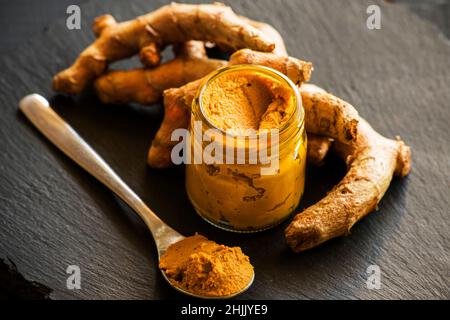 Kurkuma-Paste mit Kurkuma-Wurzel, Bestandteil der ajurvedischen Medizin goldene Milch Stockfoto