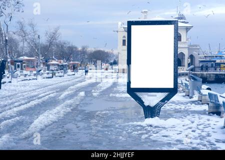 Werbeschild vor verschneiten Stadtansichten Stockfoto
