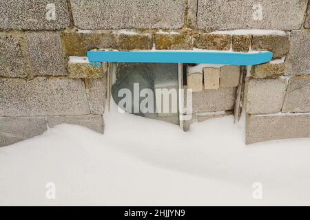 Ziegel und Ziegel vor dem Busfenster an der Vorderwand mit Schnee im Winter. Stockfoto