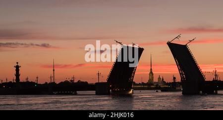 Unschärfende Stadtlandschaft. Erhöhte Palastbrücke, Fluss Neva, Rostralsäule, Peter und Paul Kathedrale. Der Himmel vor der Morgendämmerung. Ein paar Minuten vor Sonnenaufgang. Stockfoto